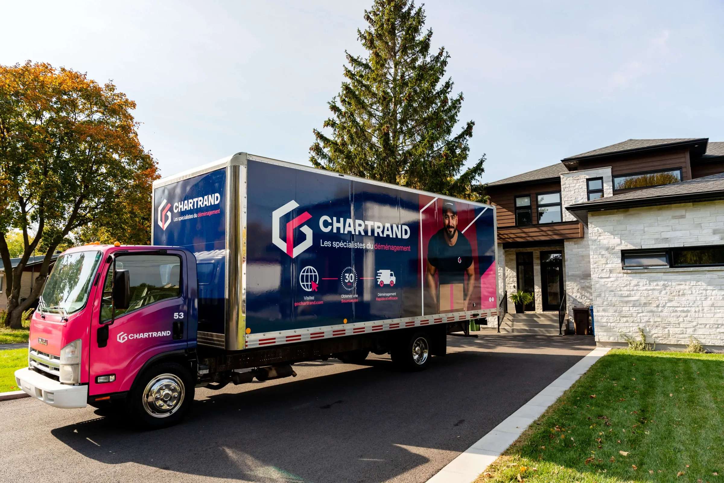 Chartrand truck parked in the driveway of a modern stone house