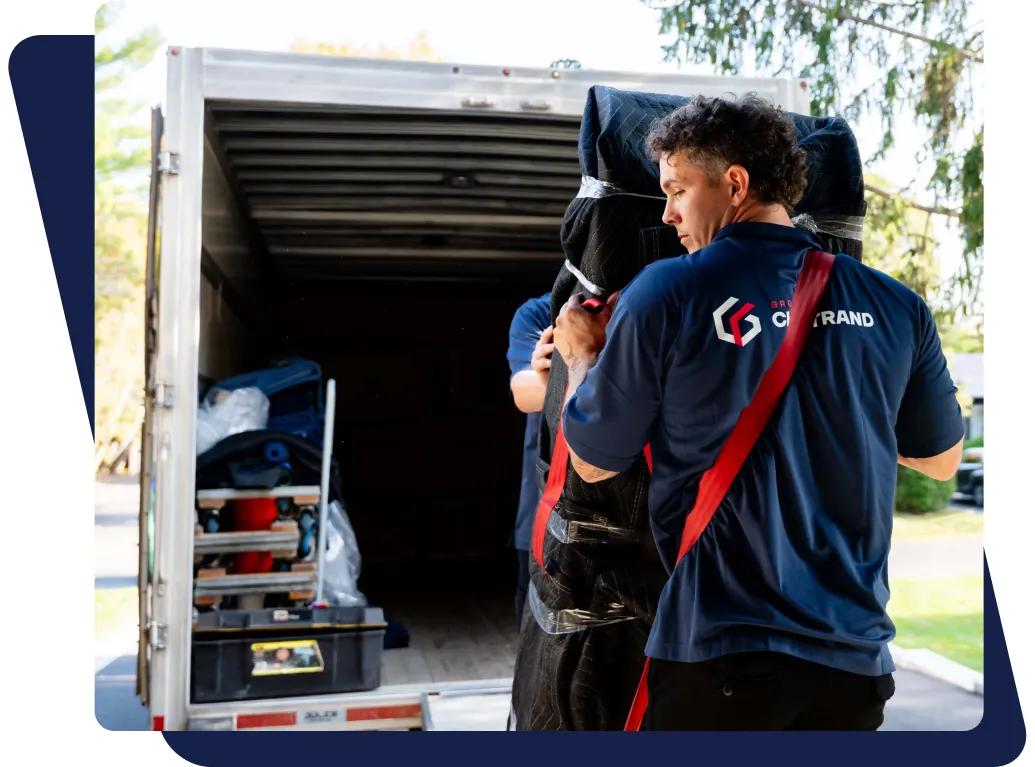 Déménageur Chartrand transportant un meuble emballé vers le camion
