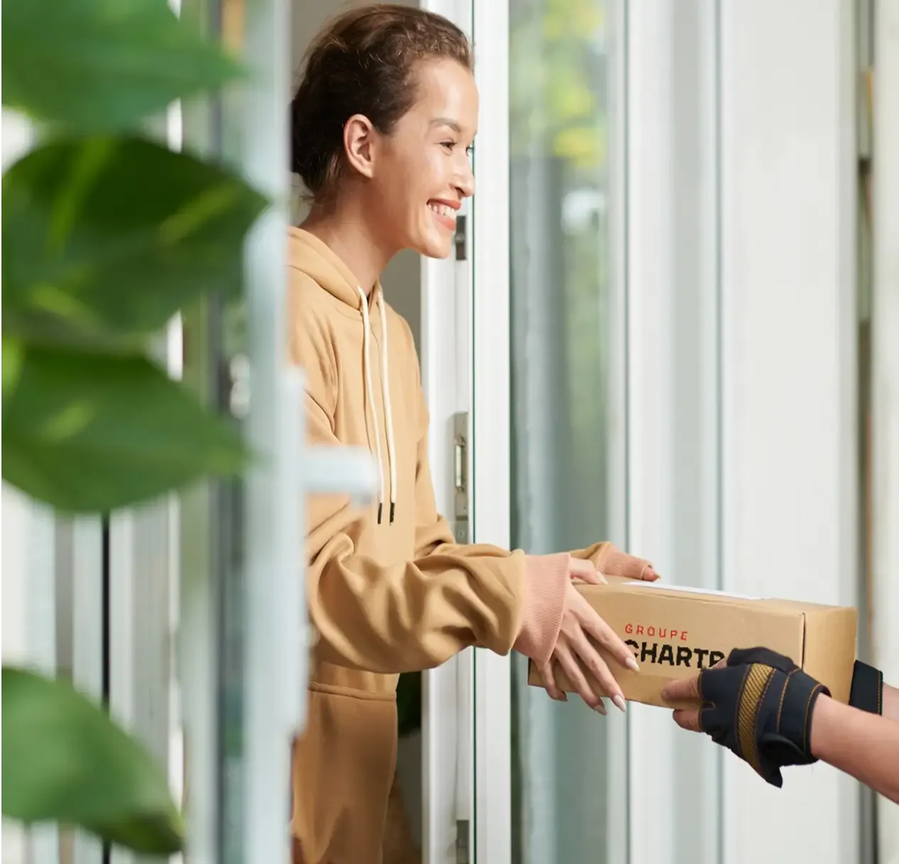 A smiling customer receives a Chartrand box at her door