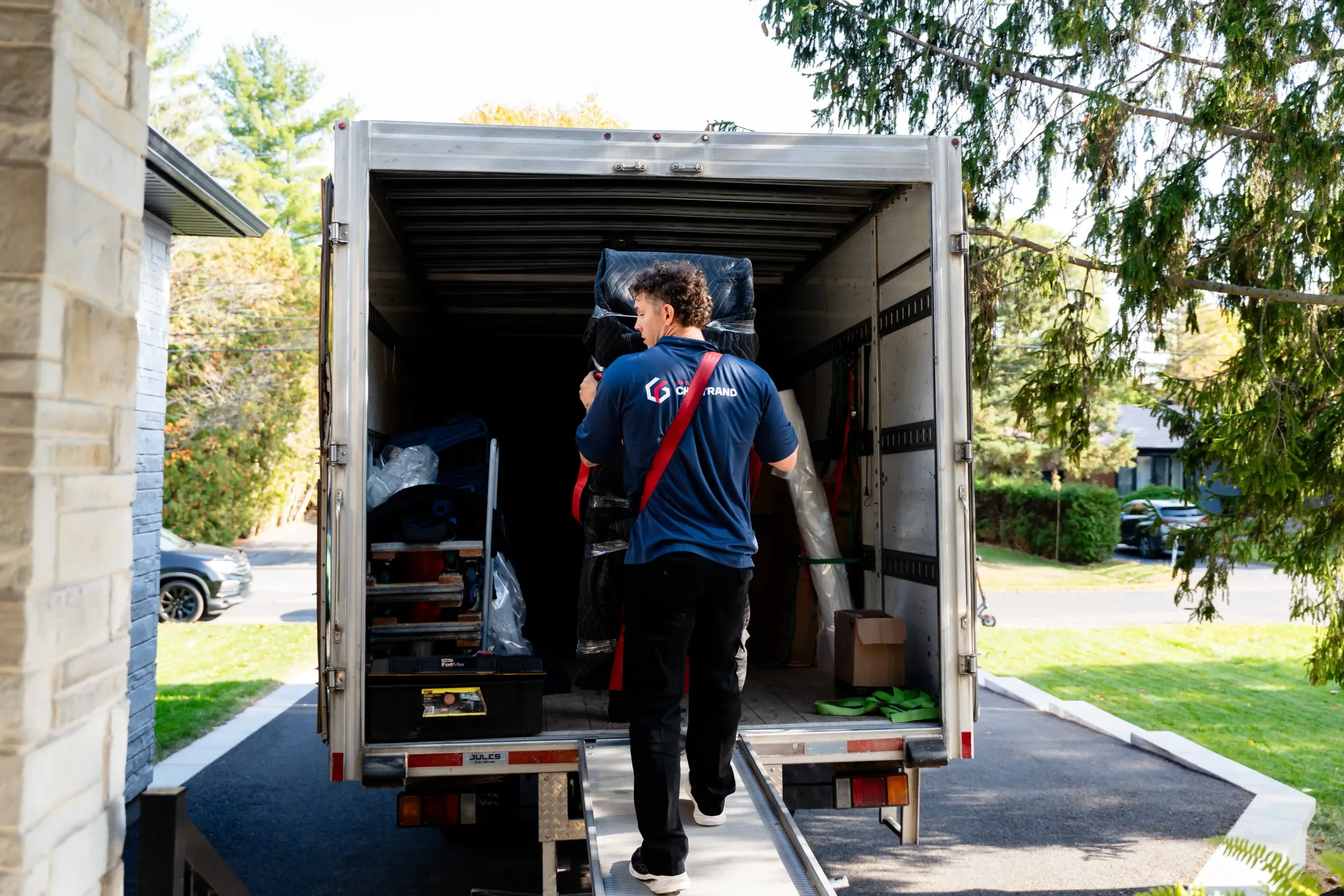 Chartrand mover on the ramp of a truck parked in front of a house