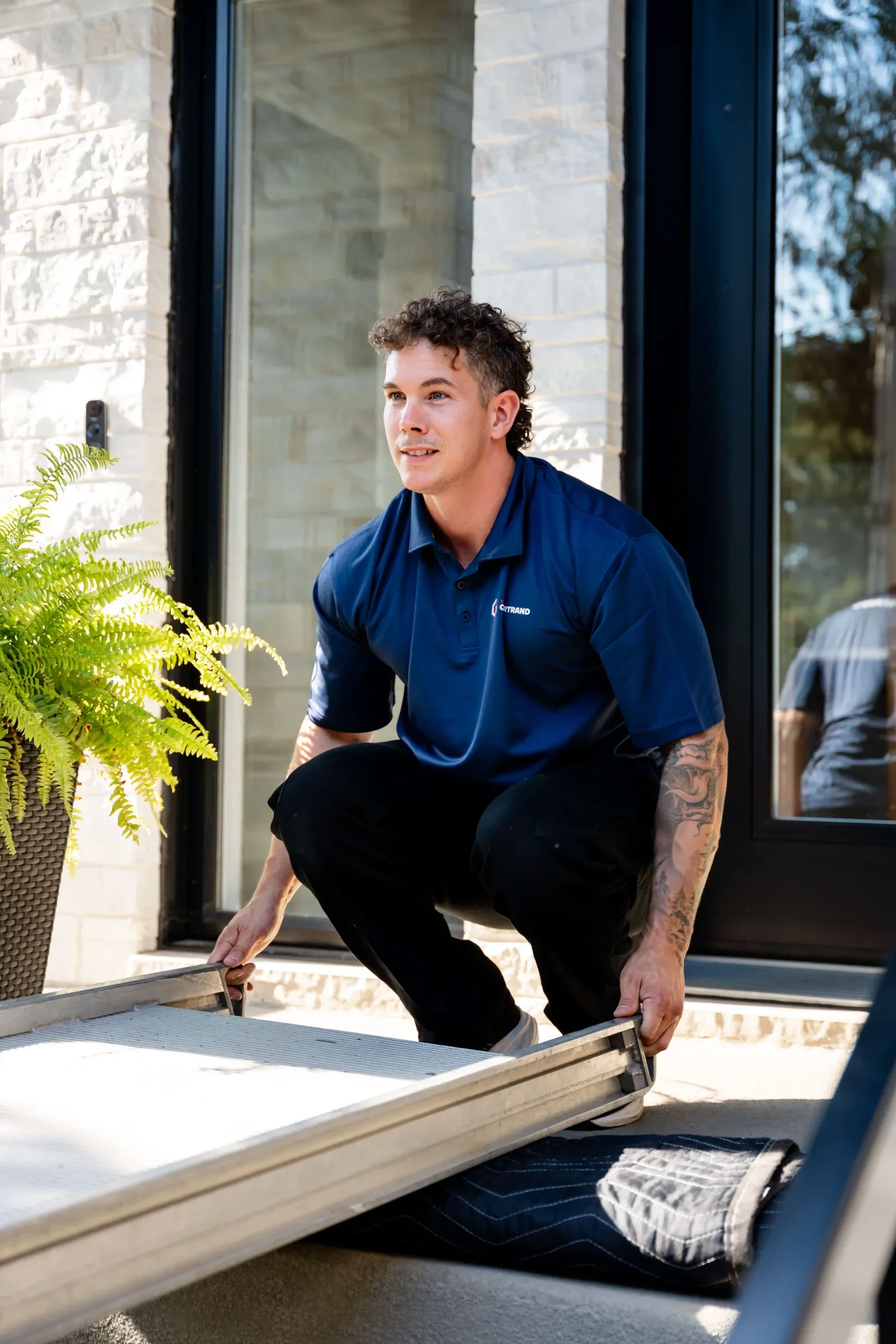 Chartrand mover lifting a piece of furniture at the threshold of a front door