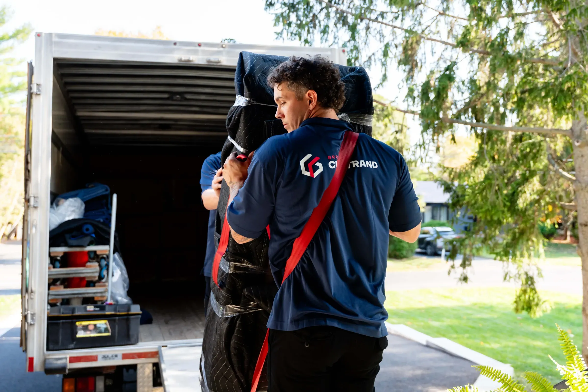 Chartrand mover wearing a carrying strap at the back of a truck