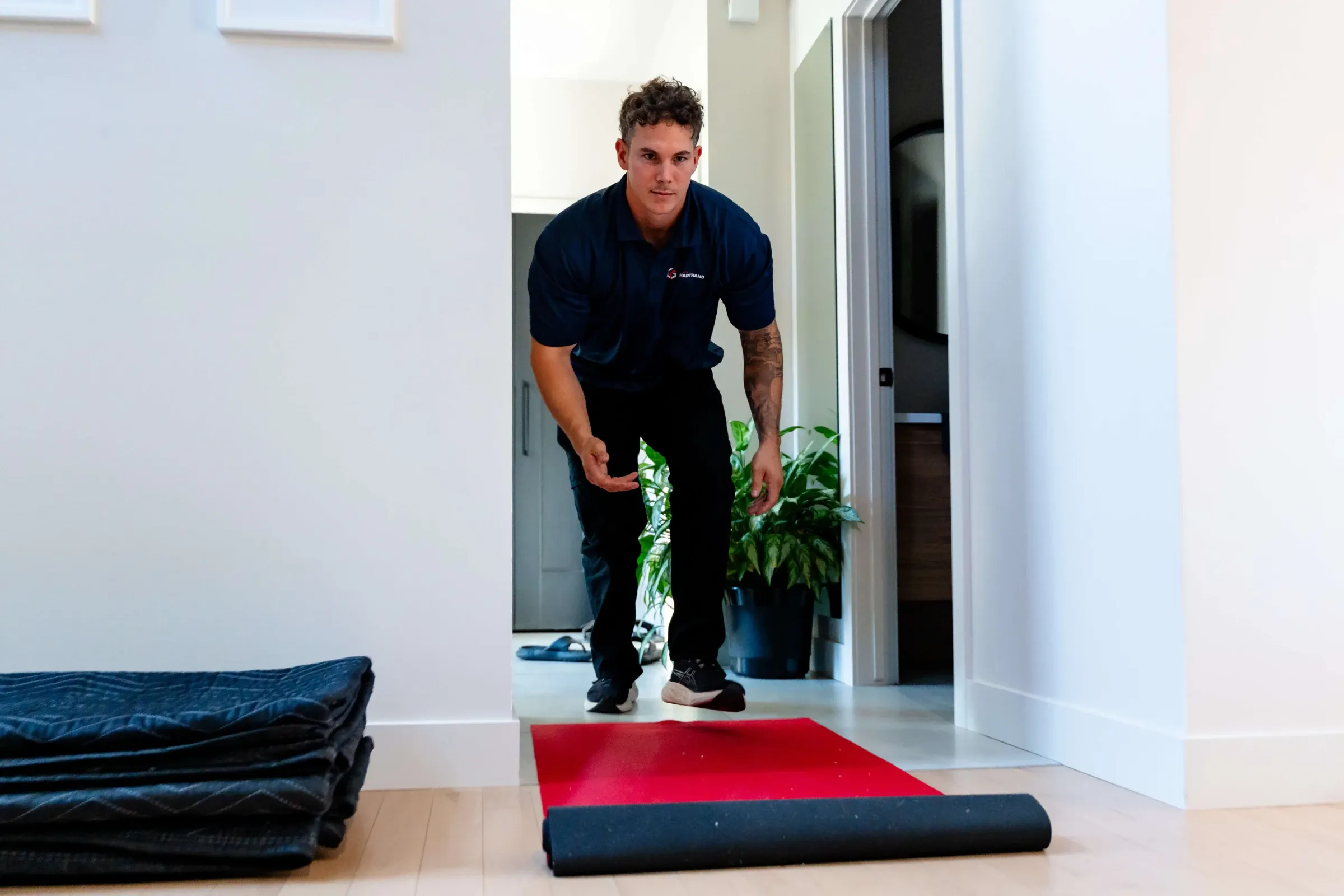 Chartrand mover unrolling a protective runner on an entryway floor