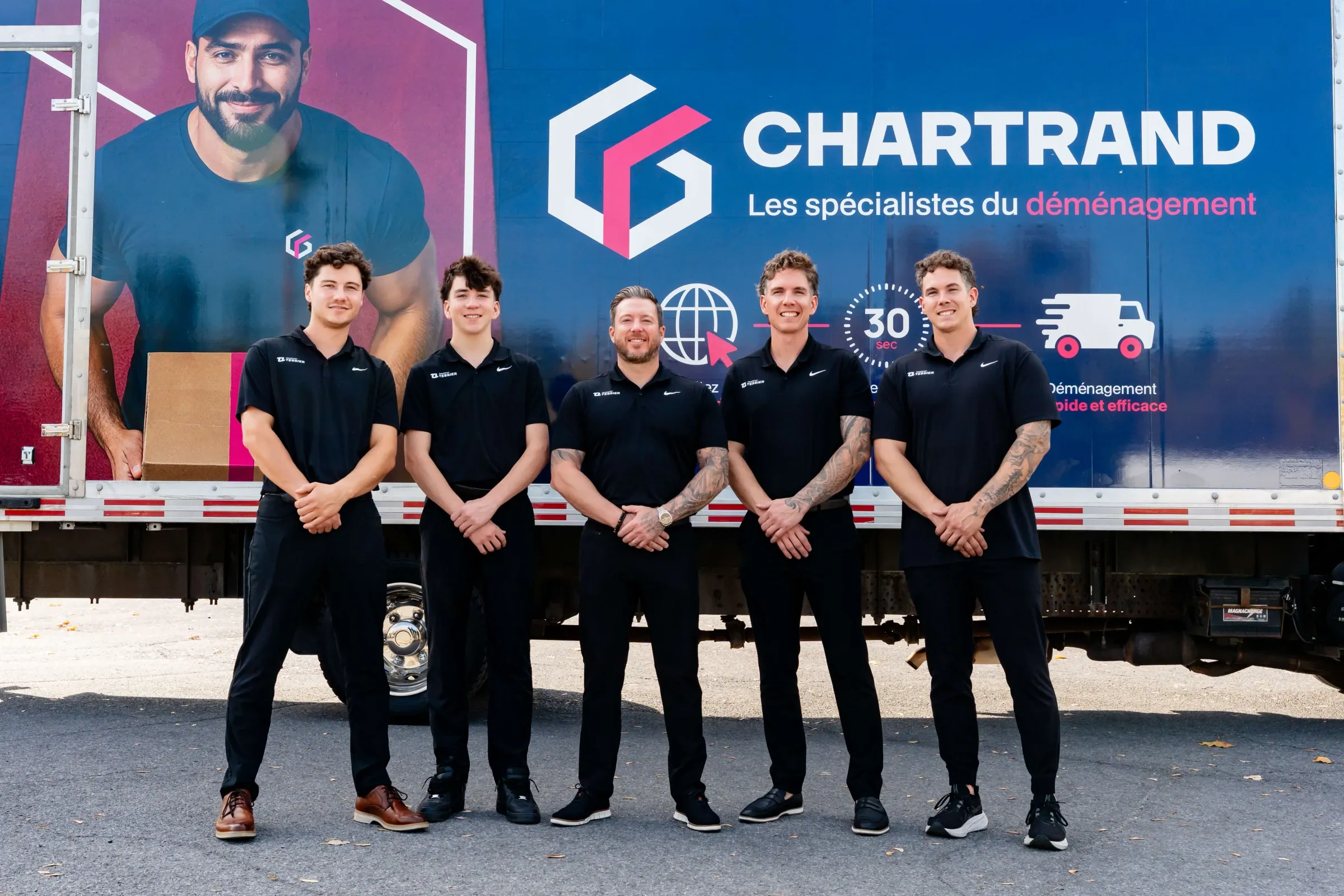 Five Chartrand team members standing in front of a Chartrand truck logo